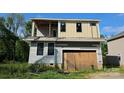 Exterior view of two-story home featuring gray siding and a garage with unfinished wood panel doors at 2725 Celia Ave, Charlotte, NC 28216