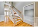 Open hallway featuring hardwood floors, a staircase with white railings, and a view into another room at 2955 Eppington South Dr, Fort Mill, SC 29708