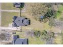 An aerial shot that showcases the home, its surrounding yard, and neighboring properties in a suburban setting at 410 E Arch St, Lancaster, SC 29720