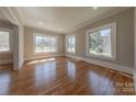 Bright living room featuring hardwood floors, multiple windows offering abundant natural light, and neutral paint at 410 E Arch St, Lancaster, SC 29720