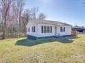 A cozy, well-maintained home with white siding and a spacious yard on a clear, sunny day at 5985 Bertie Ave, Salisbury, NC 28147