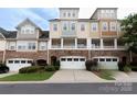 Charming townhome showcasing a stone facade, a row of garages, and manicured landscaping at 609 Sunfish Ln, Tega Cay, SC 29708