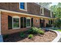 Close up of brick home with manicured landscaping, black shutters, and inviting front door at 651 25Th Nw Ave, Hickory, NC 28601