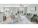Bright living room with large windows, neutral paint, and comfortable seating arrangement at 9724 Cadman Ct, Cornelius, NC 28031