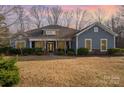 Charming single Gathering home featuring a cozy front porch and beautiful stone accents at dusk at 1061 Verbena Ct, Tega Cay, SC 29708