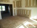 Bright, unfinished living room space featuring rough concrete floors, natural light, and an open doorway at 128 Peppervine Ln, Statesville, NC 28625