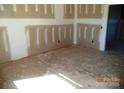 Unfinished living room with bare concrete floors, exposed drywall, and natural light at 128 Peppervine Ln, Statesville, NC 28625