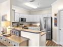 Well-lit kitchen with stainless steel appliances, white cabinets, and laminate countertops, offering modern convenience at 1410 4Th Street Nw Dr # 205, Hickory, NC 28601