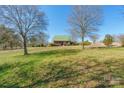 A beautiful house on a large lot with green grass and mature trees on a clear day at 1847 Bertha Knight Rd, Lancaster, SC 29720