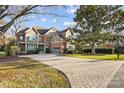 Charming home showcasing a brick driveway, lush green lawn, and mature trees at 2305 Flintwood Ln, Charlotte, NC 28226