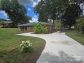 Wide concrete driveway leading to a brick home with mature trees and landscaping at 245 College E Ave, Shelby, NC 28152