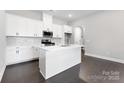 Bright kitchen boasts white cabinets, a central island, modern appliances, and elegant backsplash tile at 3105 Beacon Heights Rd, Indian Land, SC 29707