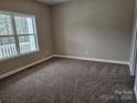 Cozy carpeted bedroom featuring a large window with natural light and a neutral color scheme at 3667 Travertine Dr, Lancaster, SC 29720