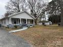 Charming single story home featuring a covered porch, well-kept lawn, and detached garage at 412 E Ross Grove Rd, Shelby, NC 28150
