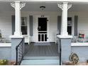 Inviting front porch featuring decorative columns, gray-painted deck, and charming furnishings at 412 E Ross Grove Rd, Shelby, NC 28150