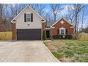 Charming home featuring a brick and siding exterior, an attached garage, and a well-manicured lawn at 4710 Nijinsky Ct, Charlotte, NC 28216