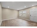 Bright living room with neutral walls, recessed lighting, new floors, and a view from the large window at 515 Culloden Ct, Charlotte, NC 28214