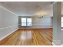 Spacious open living room with hardwood floors, chair railing, and natural light at 5513 Hammermill Dr, Harrisburg, NC 28075