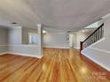 Bright and open living room featuring hardwood floors, natural light, and a staircase at 5513 Hammermill Dr, Harrisburg, NC 28075