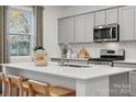 Modern kitchen featuring a large island, quartz countertops, stainless steel appliances, and ample cabinet space at 554 Mountain View Dr, Monroe, NC 28110