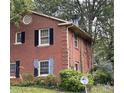 A close up of the side of a brick two-story house with mature trees in the background at 5635 Ruth Dr, Charlotte, NC 28215