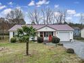 Inviting single-story home with metal roof, complemented by a well-maintained lawn and an attached garage at 609 Ben Rich St, Dallas, NC 28034