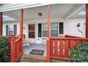 Cozy front porch with red wood trim, offering a welcoming entrance and comfortable seating area at 609 Ben Rich St, Dallas, NC 28034