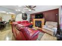 Spacious living room with a fireplace, a ceiling fan, hardwood floors, and comfortable red and tan seating at 609 Ben Rich St, Dallas, NC 28034