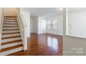 Bright living room with gleaming hardwood floors and staircase providing open space at 7147 Brighton Park Dr, Mint Hill, NC 28227