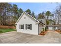 This exterior shows the side of the house with an expansive driveway and a detached garage at 7219 Morningdew Ct, Denver, NC 28037