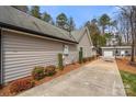 Side view of a home with gray siding and a long driveway leading to a detached garage at 7219 Morningdew Ct, Denver, NC 28037