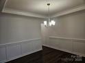 The dining room features modern dark hardwood floors, decorative trim, and an elegant chandelier at 8231 Annsborough Nw Dr, Concord, NC 28027