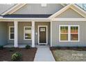 Welcoming front porch with white columns, a dark-colored door, and well-kept landscaping at 844 Westminster Dr, Statesville, NC 28677