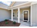 Inviting front porch with white columns, a dark-colored door, and tidy landscaping at 844 Westminster Dr, Statesville, NC 28677