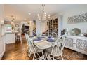 Charming dining room featuring hardwood floors, a stylish chandelier, and a decorative cabinet at 8904 Saint Pierre Ln, Charlotte, NC 28277