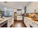 Bright kitchen featuring brick backsplash, white cabinets, stainless appliances, granite countertops, and hardwood floors at 8904 Saint Pierre Ln, Charlotte, NC 28277