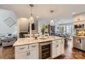 Open-concept kitchen featuring an island with granite countertop, wine fridge, and dining area at 8904 Saint Pierre Ln, Charlotte, NC 28277