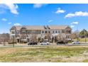 A row of townhomes on a tree lined street, with parked cars in front at 9108 Ainslie Downs St, Charlotte, NC 28273