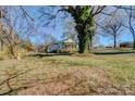 Quaint home nestled amongst mature trees with a large grassy front yard and partially covered front porch at 966 Marys Grove Rd, Cherryville, NC 28021