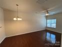 Bright living room with hardwood floors, chandelier and a ceiling fan, and natural light from a window at 13615 Browhill Ln, Charlotte, NC 28278