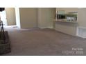 Open-concept living room with neutral carpet, view to kitchen and fireplace at 1629 & 1631 Harris Rd # 6&7, Fort Mill, SC 29708