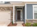 Home entrance featuring a modern wood door, stone accents, and well-maintained landscaping at 19011 Dry Narrows Way, Charlotte, NC 28278