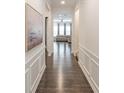 Hallway with beautiful hardwood floors and decorative wainscoting leading to the living area at 19011 Dry Narrows Way, Charlotte, NC 28278