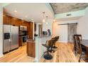Bright kitchen and dining area with stainless steel appliances, breakfast bar with three stools, and a sliding barn door at 210 N Church St # 1507, Charlotte, NC 28202
