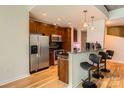 Modern kitchen with stainless steel appliances, dark wood cabinets, and a granite breakfast bar at 210 N Church St # 1507, Charlotte, NC 28202