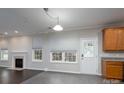 Living area with dark hardwood floors, a fireplace, and neutral walls leading to a tiled kitchen at 303 Basswood Ct, Clover, SC 29710