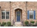 Charming front entrance with stone detail, blue door, and colorful flower accents at 3045 Bronwood Pl, Lancaster, SC 29720
