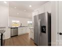 Bright kitchen with stainless steel appliances, granite countertops, white cabinets, and hardwood flooring at 3528 Narrow Ln, Charlotte, NC 28215