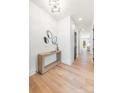 Bright entryway featuring hardwood floors, modern light fixture, contemporary console table and accent mirrors at 3937 Plainview Rd, Charlotte, NC 28208