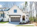 Modern farmhouse with two-car garage, board and batten siding, and covered front porch at 3953 Plainview Rd, Charlotte, NC 28208